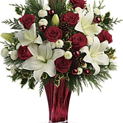 Send them the wonders of winter with beautiful red roses, snow white lilies and fresh winter greens arranged in an elegant glass vase.

Red roses, white asiatic lilies and white button chrysanthemums are accented with fresh flat cedar, variegated holly, white pine, pinecones and red ornament balls.