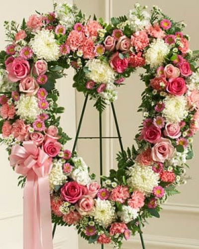 Commemorate them and the special place they will always hold in your heart with this heart-shaped floral arrangement. Crafted by our expert florists using fresh pink and white flowers including roses, stock, carnations and more, it's a beautiful way to send your deepest condolences to family, friends or any special person in your life. Traditionally sent directly to the funeral home by family members or friends and displayed on a stand.