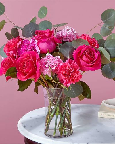 Who knew hugs and kisses could grow on trees? Blooming with jewel–toned carnations and hot pink roses surrounded by adorable eucalyptus stems, this florist-crafted arrangement will make them feel extra loved.