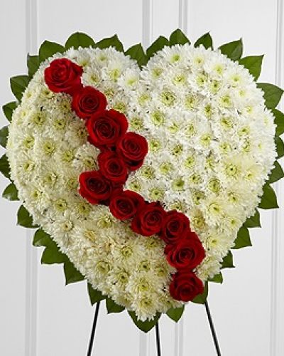 The FTD® Broken Heart™ is a beautiful way to express the impact that the departed had on your life. Pearly white chrsyanthemums form the shape of a heart, accented with greens lined around the outside and "broken" in the middle with a line of rich red roses to create an exqusite way to honor the life of the deceased at their memorial service. Displayed on a wire easel.